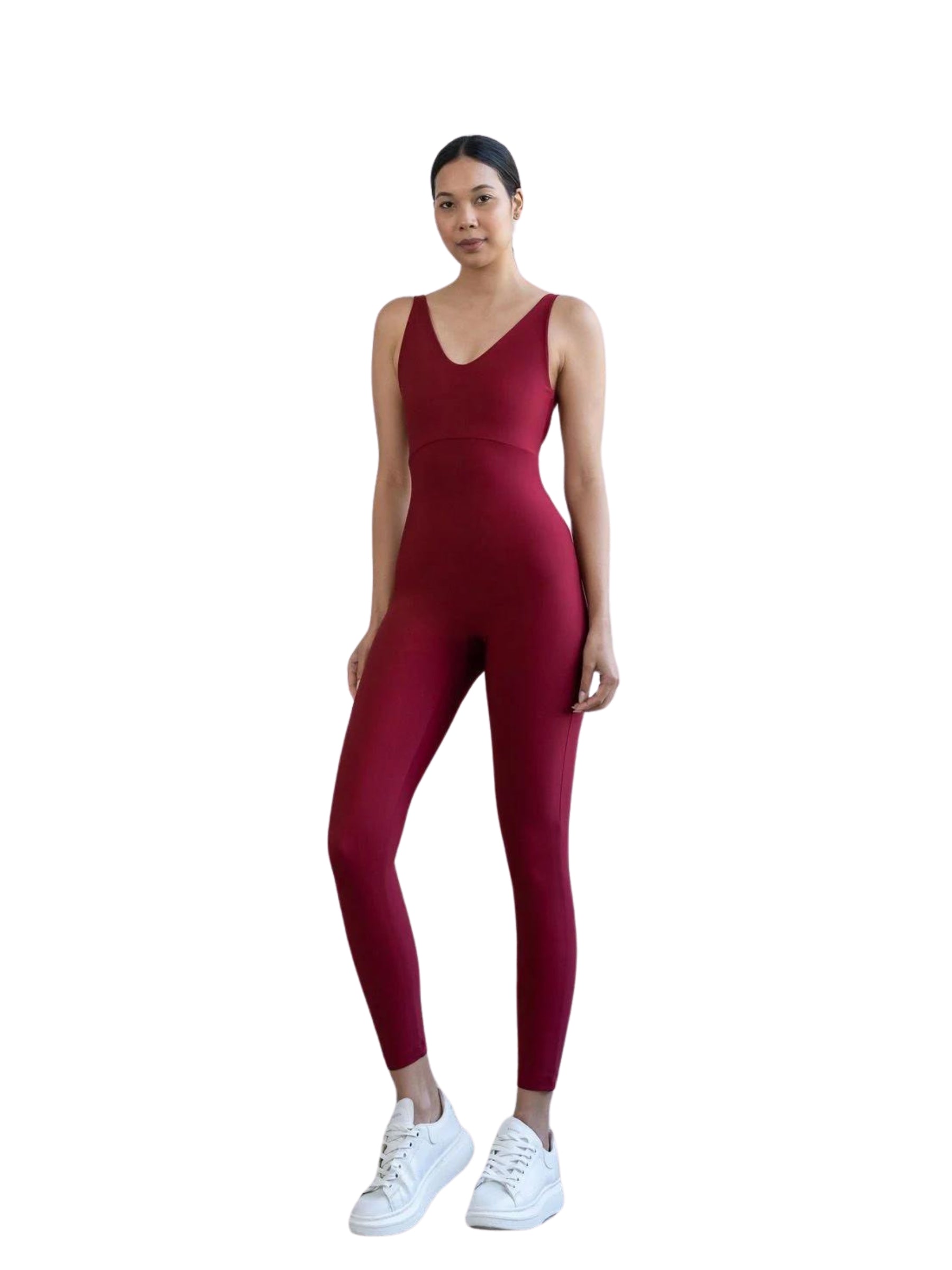Eine Person in einem bordeauxroten Lismina 2101 Double Cross Jumpsuit und weißen Turnschuhen steht vor einem weißen Hintergrund.